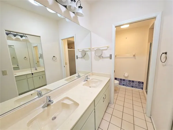 a spacious bathroom with a shower sink and mirror