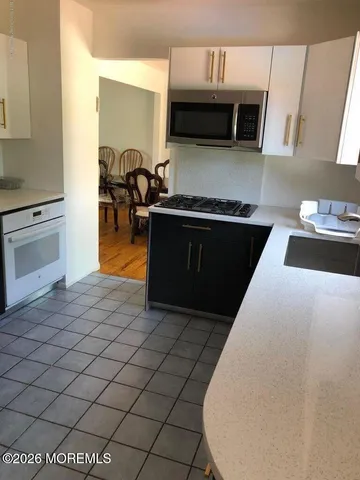 a kitchen with granite countertop a stove and a microwave