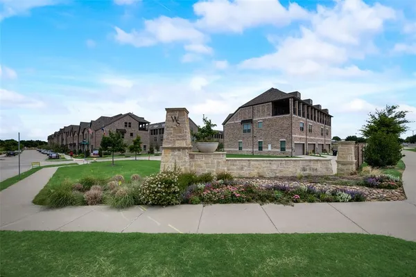 a view of a house with a big yard plants and large trees