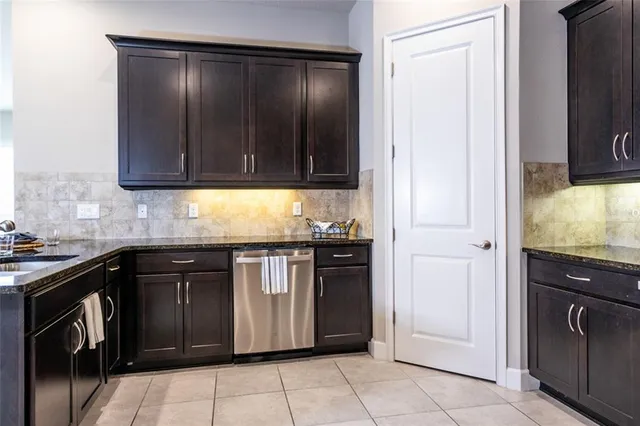 a kitchen with granite countertop a cabinets and steel stove top oven
