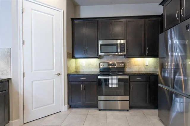 a kitchen with granite countertop stainless steel appliances and wooden cabinets