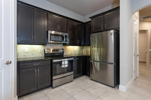 a kitchen with granite countertop stainless steel appliances and refrigerator