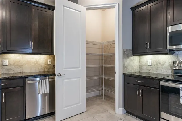 a kitchen with granite countertop a refrigerator and a sink