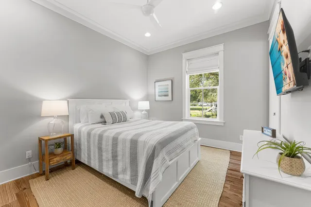 a bedroom with a bed wooden floor and window