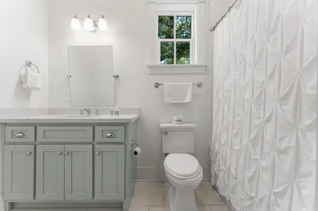 a bedroom with a bed and a window with wooden floor