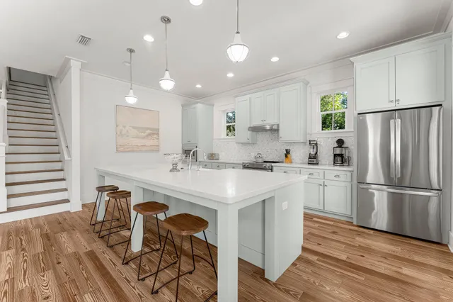 a kitchen with a dining table chairs and cabinets