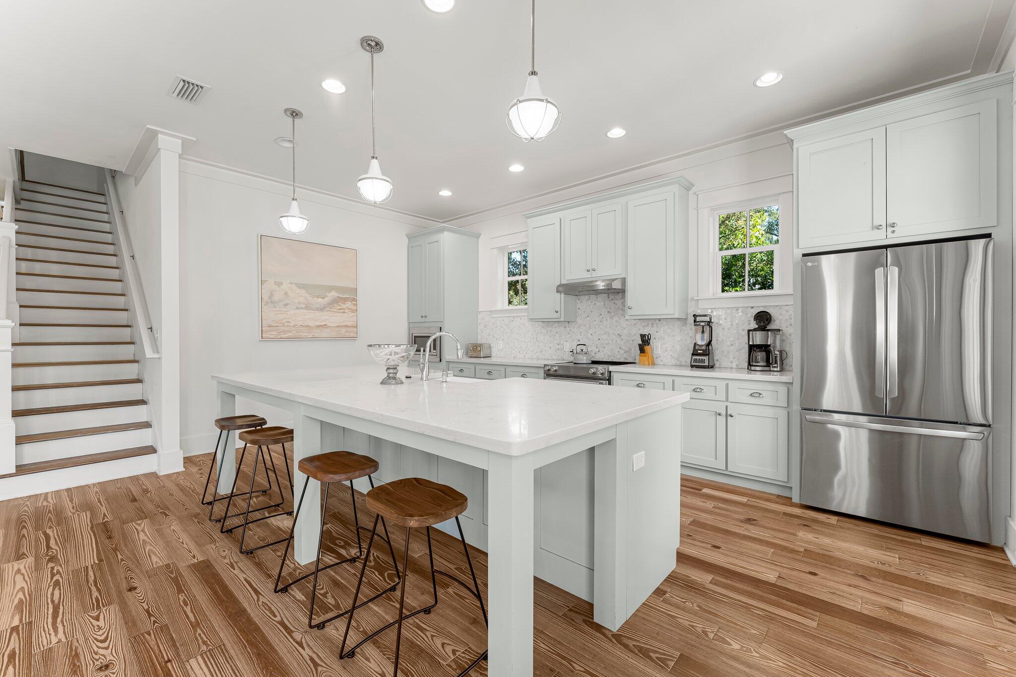 515 Seacrest Drive Inlet Beach, FL 32461 - Photo 7 of 62 a kitchen with stainless steel appliances granite countertop a sink a stove a refrigerator and island with wooden floor