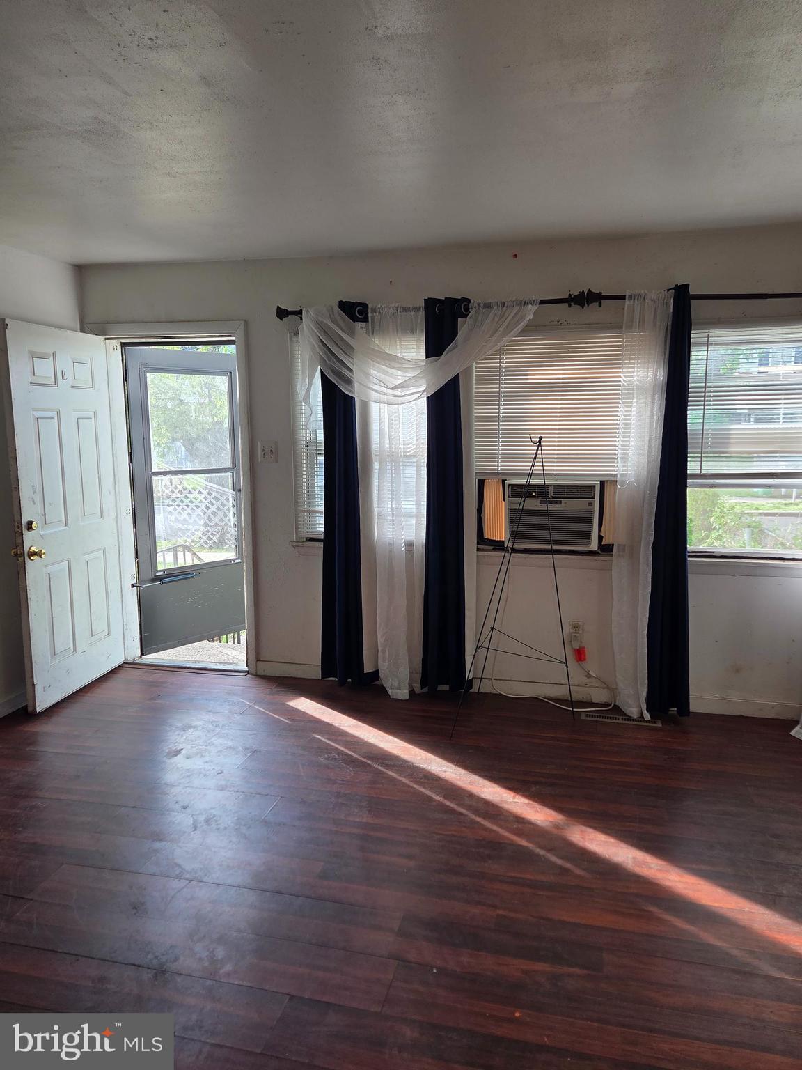 5706 Mitchell Road Levittown, PA 19057 - Photo 4 of 7 a view of an empty room with wooden floor and a window