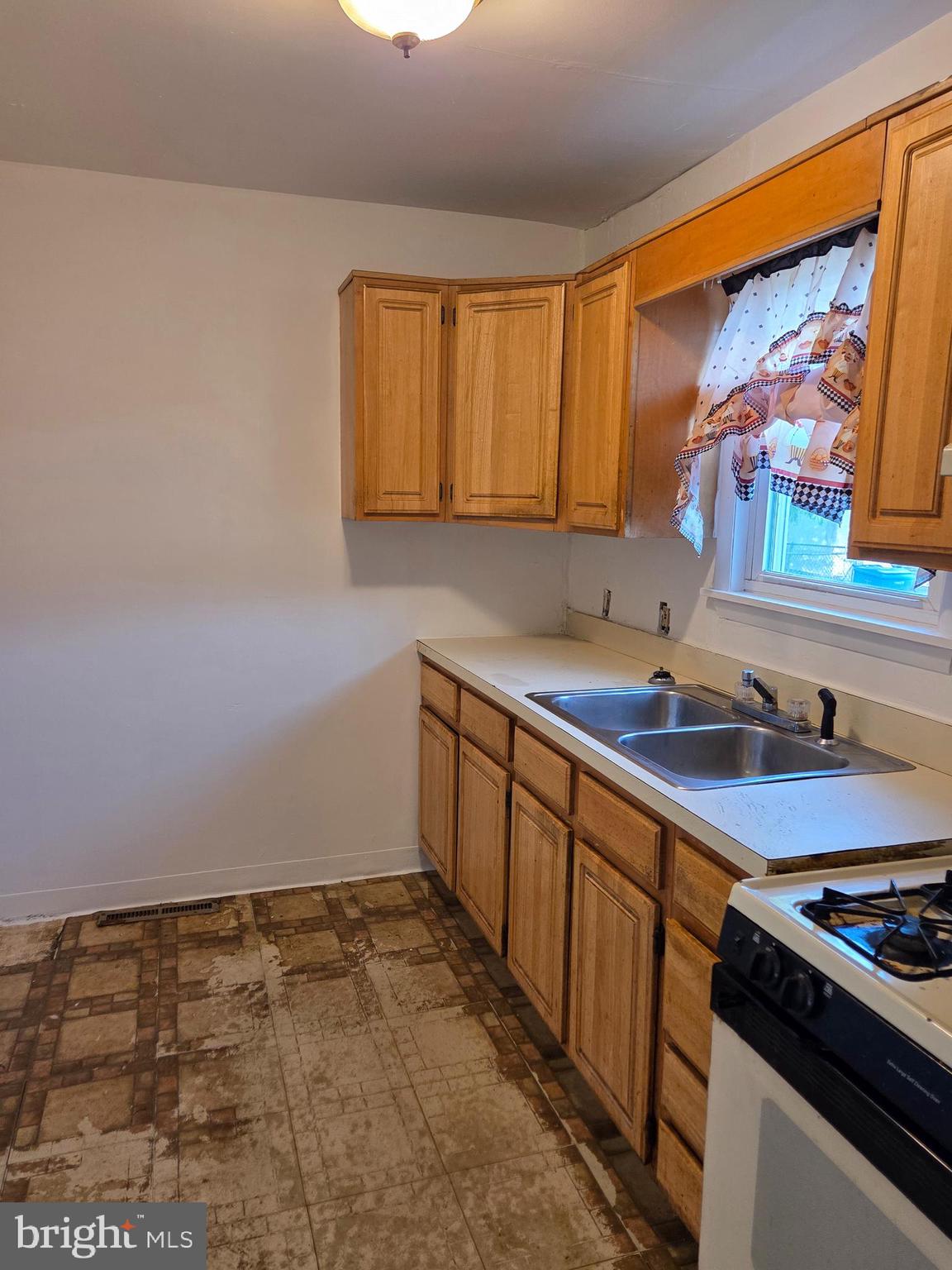 5706 Mitchell Road Levittown, PA 19057 - Photo 7 of 7 a kitchen with stainless steel appliances a sink stove and cabinets