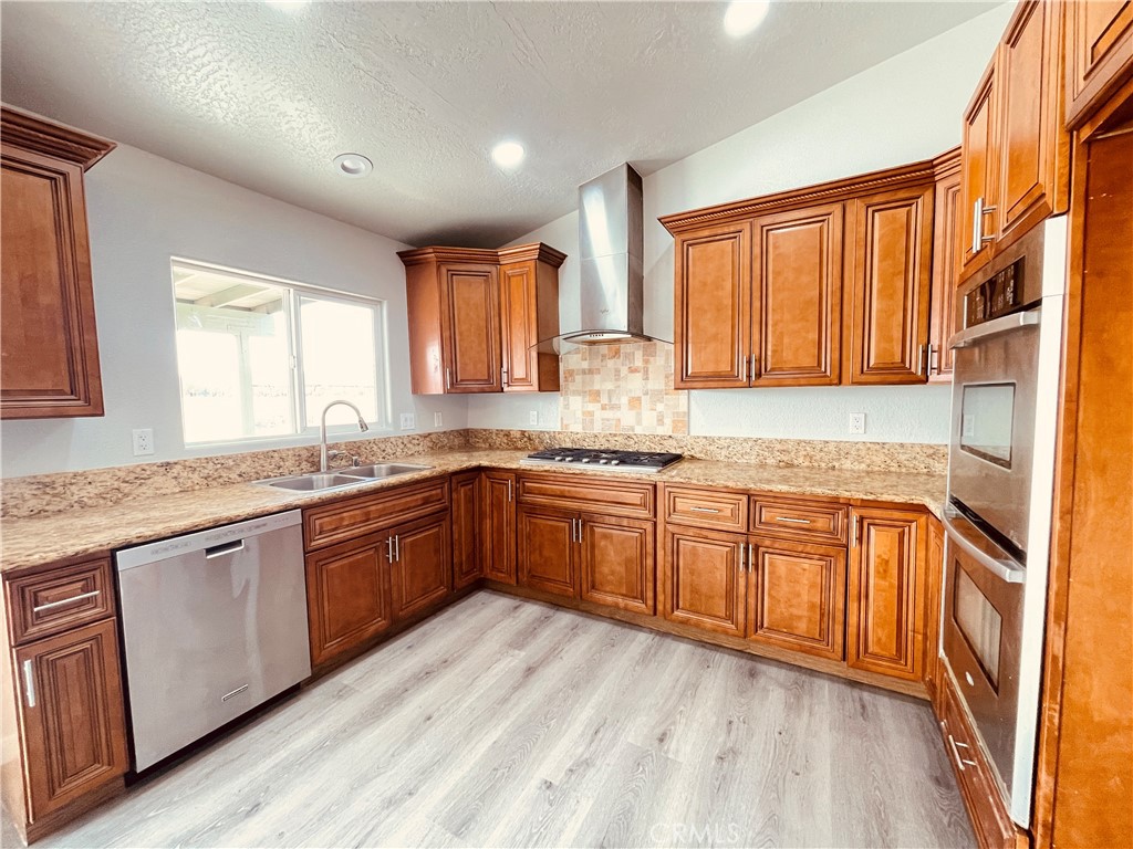 20891 Thunderbird Road Apple Valley, CA 92307 - Photo 22 of 45 a kitchen with stainless steel appliances granite countertop wooden cabinets a sink and a granite counter tops with a large window