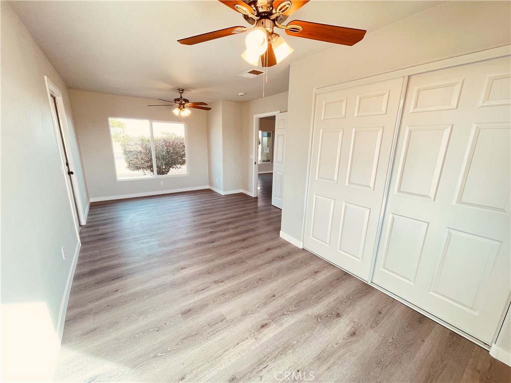 20891 Thunderbird Road Apple Valley, CA 92307 - Photo 25 of 45 an empty room with wooden floor fan and windows