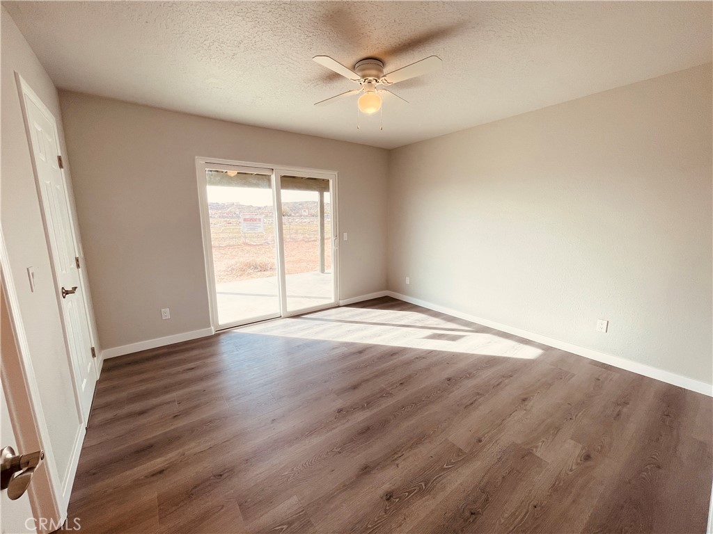 20891 Thunderbird Road Apple Valley, CA 92307 - Photo 31 of 45 an empty room with wooden floor and windows