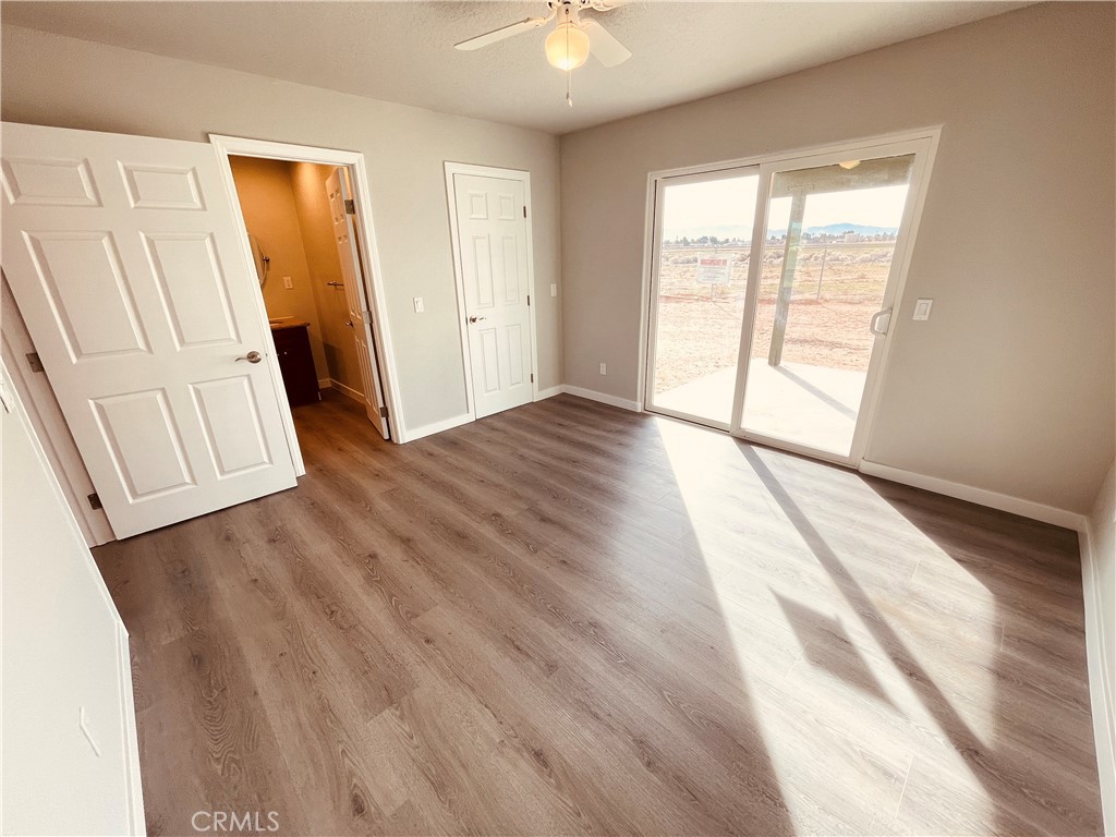 20891 Thunderbird Road Apple Valley, CA 92307 - Photo 32 of 45 an empty room with wooden floor and a window