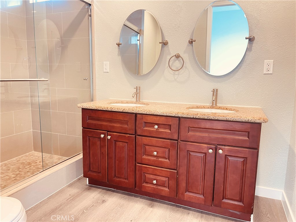 20891 Thunderbird Road Apple Valley, CA 92307 - Photo 34 of 45 a bathroom with a granite countertop tub a sink and a mirror