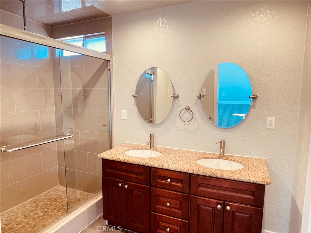 20891 Thunderbird Road Apple Valley, CA 92307 - Photo 35 of 45 a bathroom with a double vanity sink and a mirror