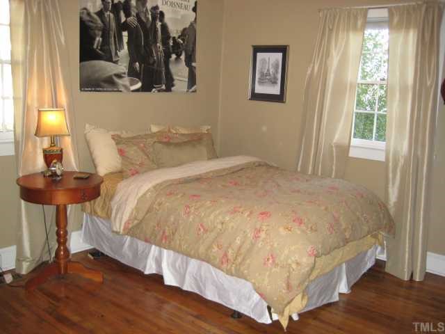 506 Burton Street Raleigh, NC 27608 - Photo 5 of 6 a large bed sitting in a bedroom next to a window