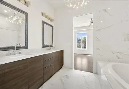an empty room with wooden floor cabinet and windows
