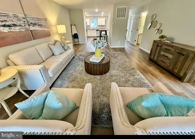 a living room with furniture and a wooden floor