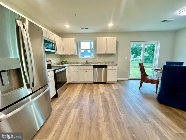 a kitchen with sink a refrigerator and wooden floor
