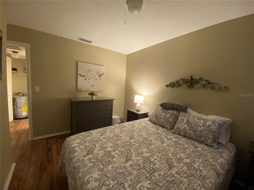 9609 Midiron Court, Unit 1 New Port Richey, FL 34655 - Photo 16 of 16 a bedroom with a bed and wooden floor