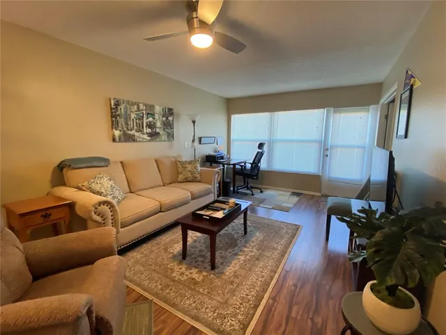 a living room with furniture and a wooden floor