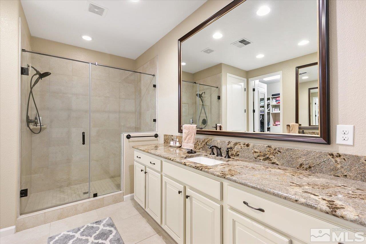 2280 Trakehner Lane Reno, NV 89521 - Photo 13 of 24 a bathroom with a granite countertop sink mirror and shower