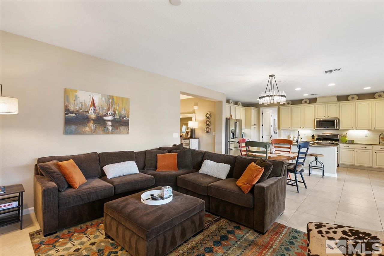 2280 Trakehner Lane Reno, NV 89521 - Photo 9 of 24 a living room with furniture a chandelier and a dining table