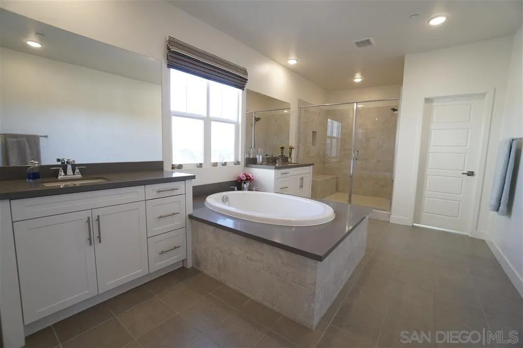 8831 Weston Road Santee, CA 92071 - Photo 11 of 25 a bathroom with a granite countertop sink a toilet a mirror and a window