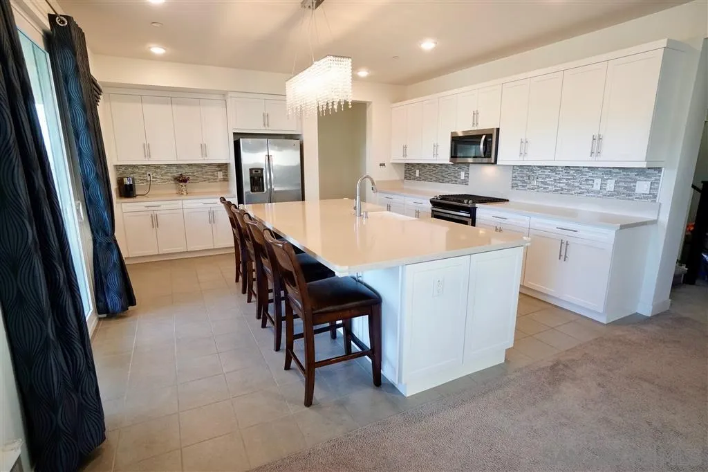 8831 Weston Road Santee, CA 92071 - Photo 6 of 25 a large kitchen with kitchen island a sink a stove a microwave and cabinets