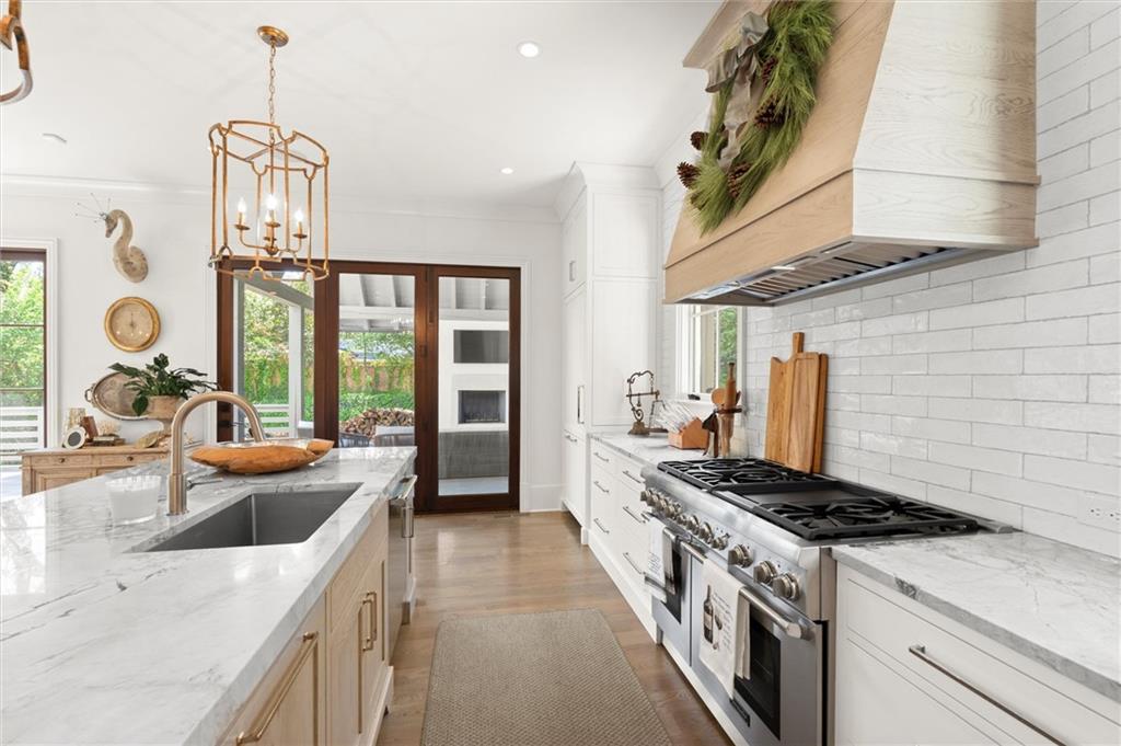 4240 Paces Ferry Road Southeast Atlanta, GA 30339 - Photo 16 of 66 a kitchen with stainless steel appliances granite countertop a sink a stove and a wooden floor