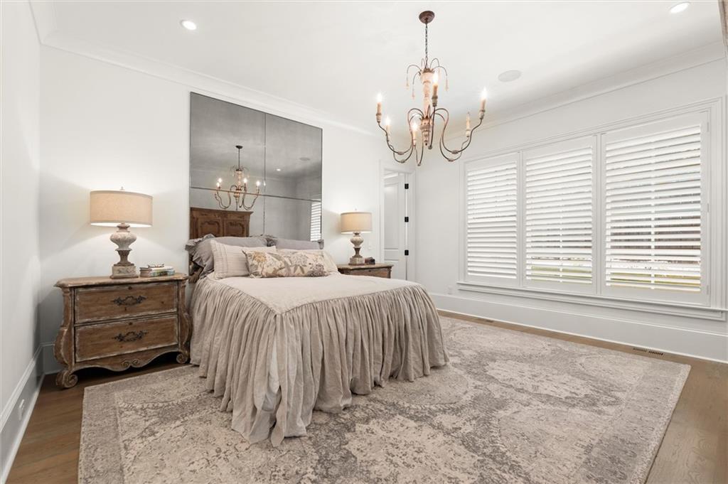 4240 Paces Ferry Road Southeast Atlanta, GA 30339 - Photo 29 of 66 a spacious bedroom with a bed and a chandelier