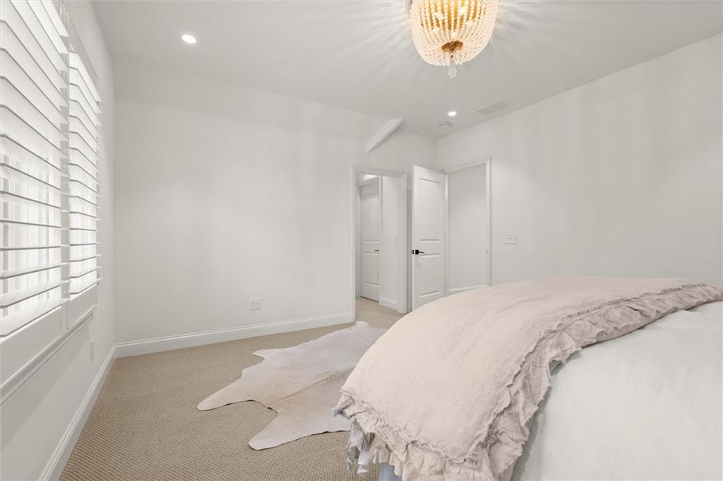 4240 Paces Ferry Road Southeast Atlanta, GA 30339 - Photo 49 of 66 a spacious bedroom with a bed and a chandelier
