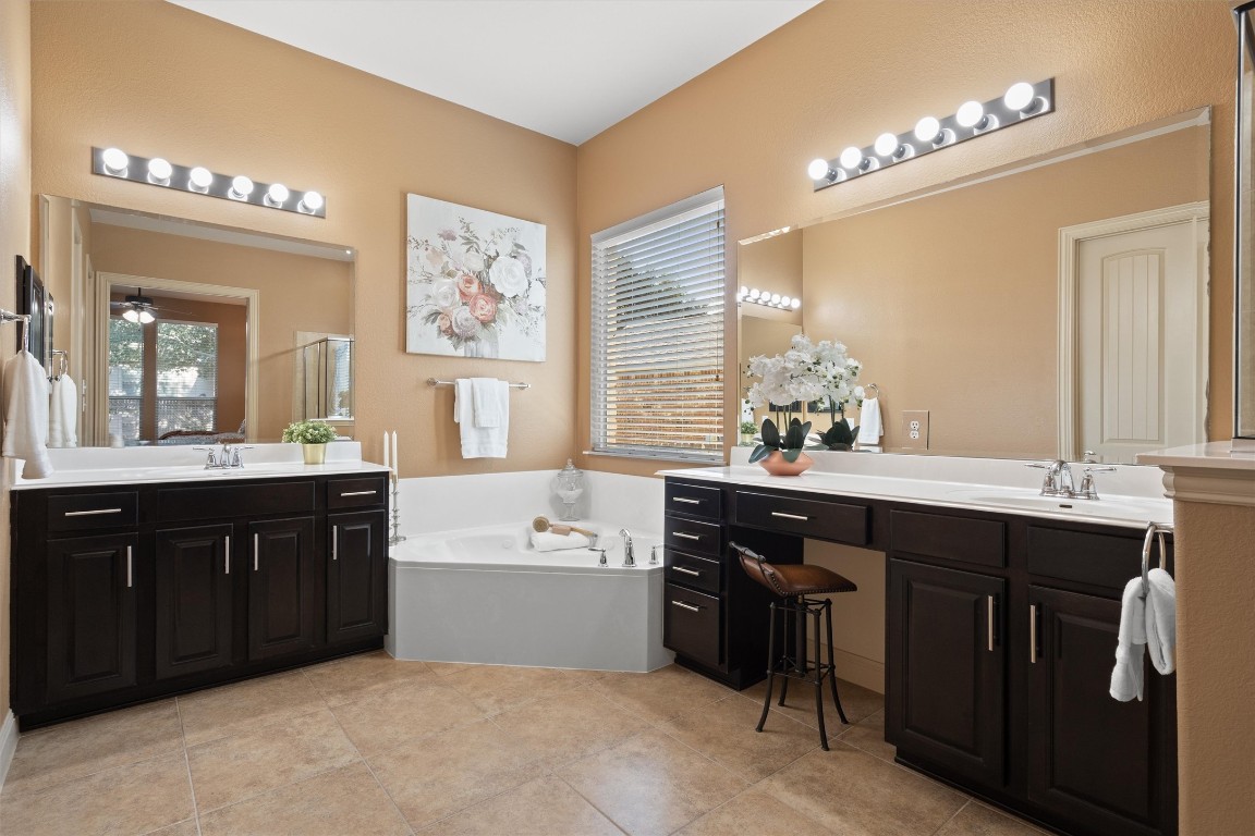 1425 Naranjo Drive Georgetown, TX 78628 - Photo 37 of 38 a spacious bathroom with a double vanity sink a large mirror and a bathtub
