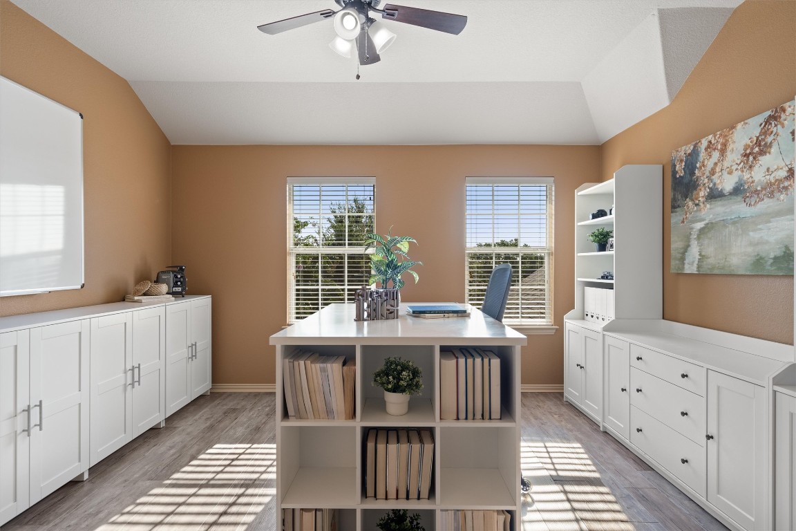 1425 Naranjo Drive Georgetown, TX 78628 - Photo 26 of 38 a kitchen with stainless steel appliances kitchen island granite countertop a table chairs in it and wooden floors