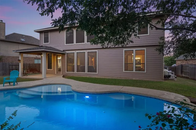 a kitchen with stainless steel appliances kitchen island granite countertop a table chairs in it and wooden floors