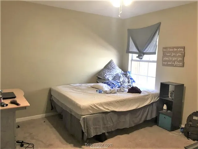 a bed sitting in a bedroom next to a window