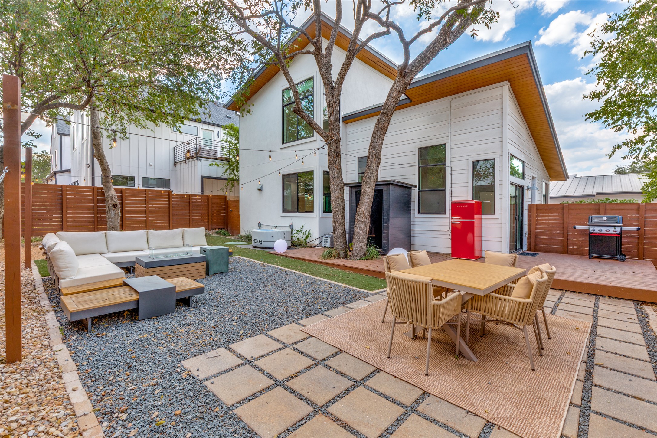 a backyard of a house with barbeque oven table and chairs