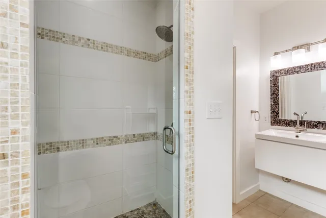 a bathroom with a double vanity sink mirror and shower
