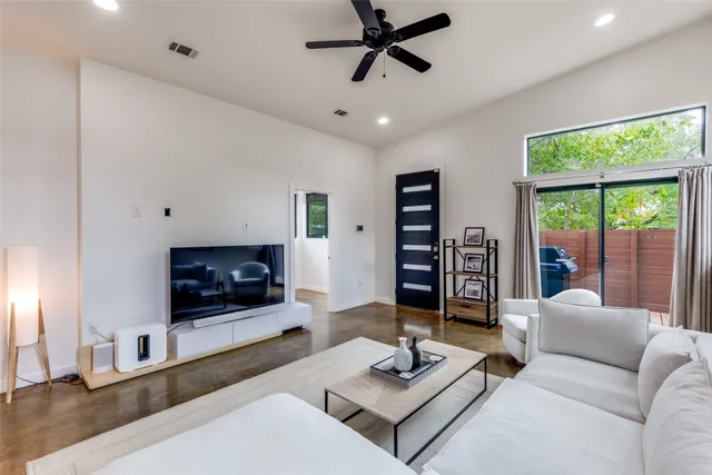 a living room with furniture a fireplace and a large window