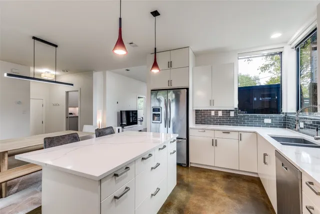 a kitchen with granite countertop a sink a center island stainless steel appliances and cabinets