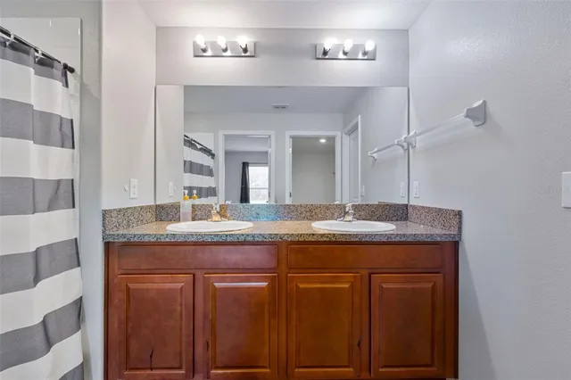 a bathroom with a granite countertop sink and a mirror
