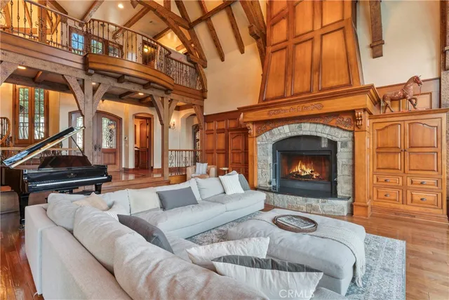 a living room with furniture large windows and wooden floor