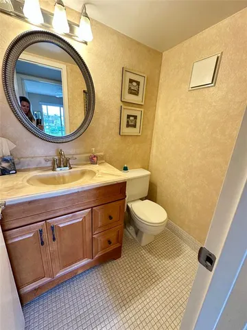 a bathroom with a toilet a sink and mirror
