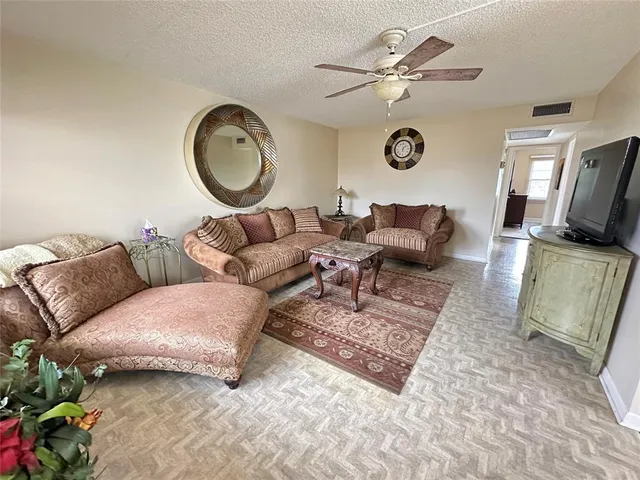 a living room with furniture a clock and a window