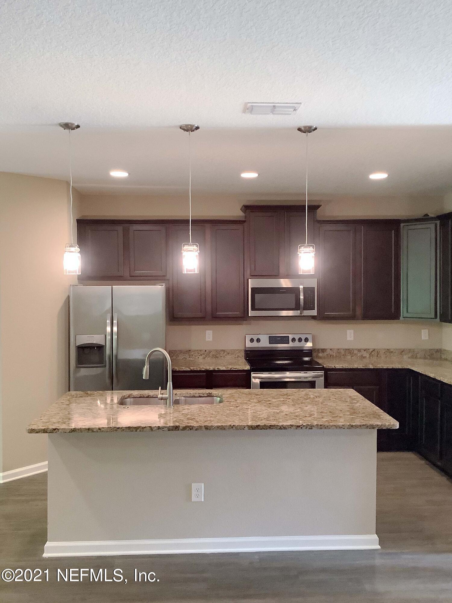 1579 Lockend Road Jacksonville, FL 32221 - Photo 4 of 15 a kitchen with kitchen island a sink and a stove with wooden floor