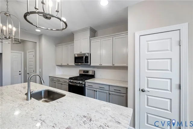 a kitchen with stainless steel appliances a sink stove and cabinets