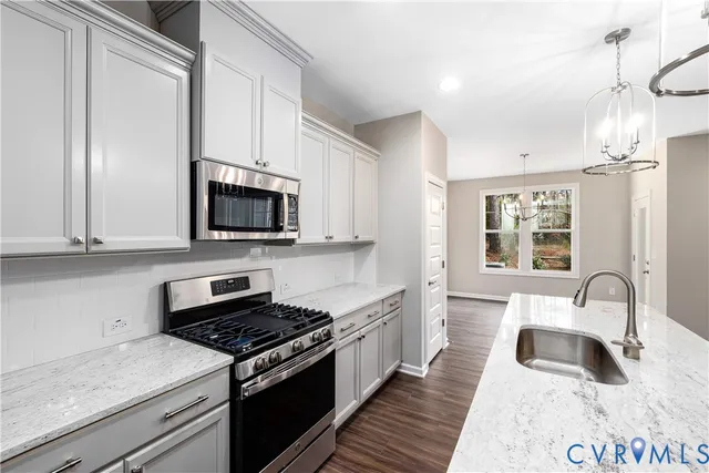 a kitchen with stainless steel appliances granite countertop a sink stove and cabinets