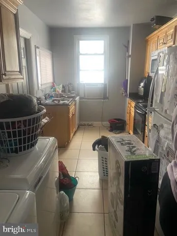 a kitchen with a sink a stove a washer dryer and a refrigerator