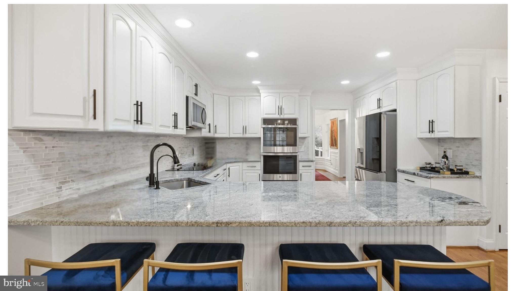 11728 Stuart Mill Road Oakton, VA 22124 - Photo 26 of 88 a kitchen with stainless steel appliances granite countertop a table and chairs in it