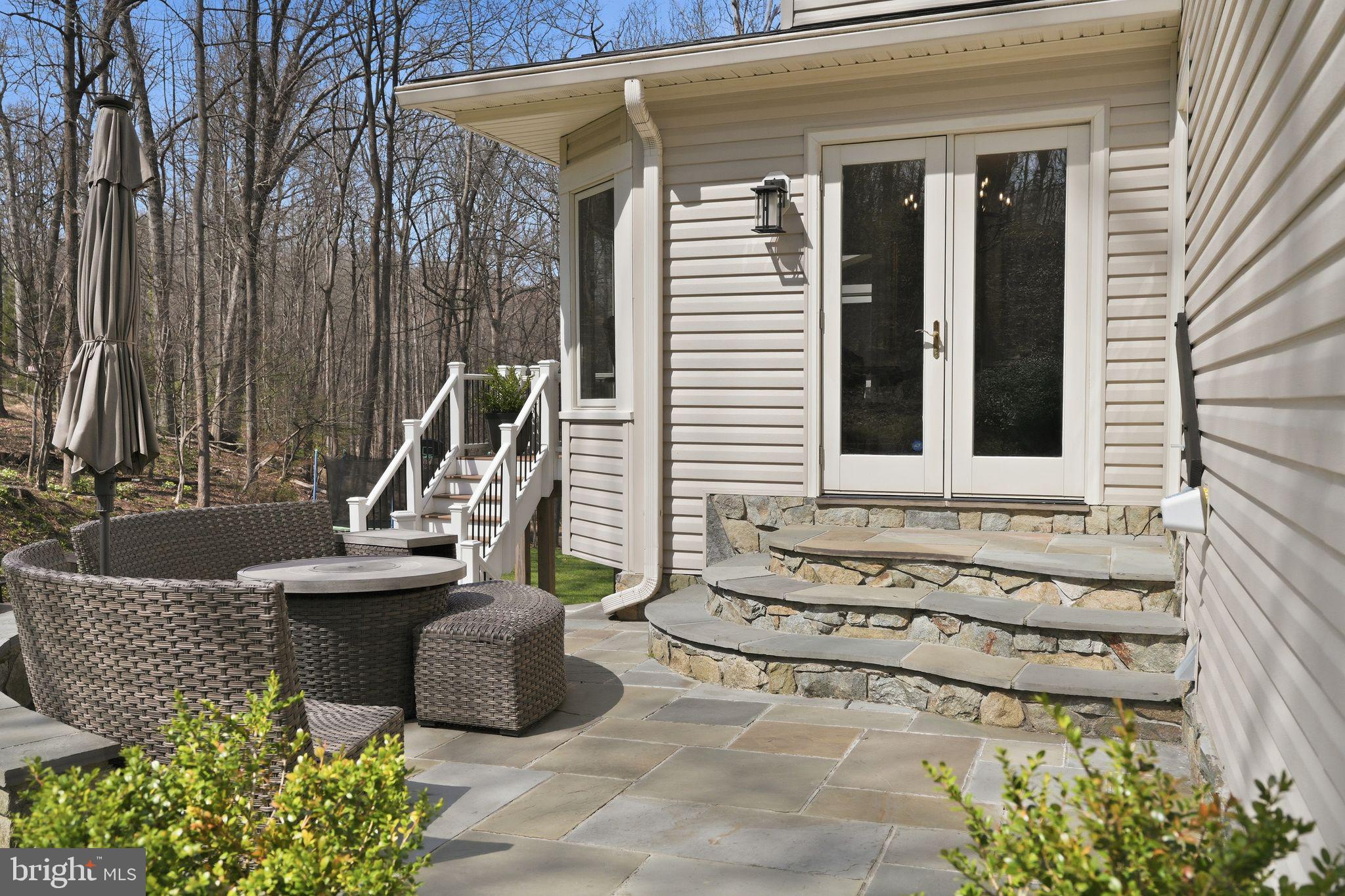 11728 Stuart Mill Road Oakton, VA 22124 - Photo 78 of 88 a view of a brick house with potted plants and a bench